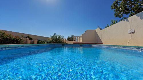 a swimming pool with blue water in front of a building at Casa Fole in Boliqueime