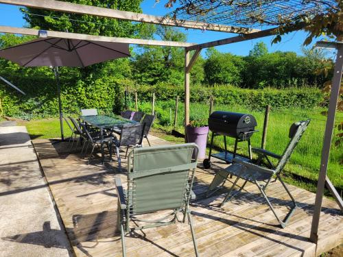 a patio with a table and chairs and a grill at Les Gîtes de la chapelle blanche in Anor