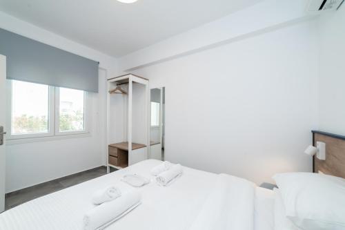 a white bedroom with a large bed and a window at Danai & Palm Stay Complex by Horizon Homes in Ofrínion