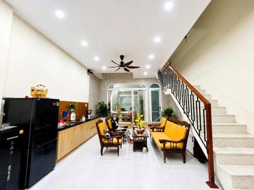 a living room with yellow chairs and a staircase at Punica Homestay in Tuy Hoa