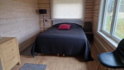 a small bedroom with a bed with a pink pillow at Taga-Kalda in Nüpli