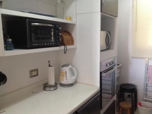 a kitchen with a counter top with a microwave at Departamento Marina Peñuelas in La Serena