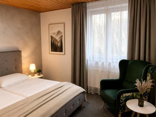 a bedroom with a bed and a chair and a window at Vila Zornička in Ždiar