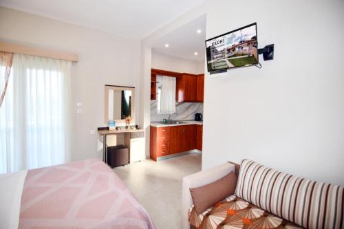 a living room with a couch and a kitchen at EXOHI STUDIOS in Sarti