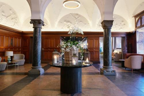 a lobby with a table with flowers and candles at Ascot Hotel in Copenhagen