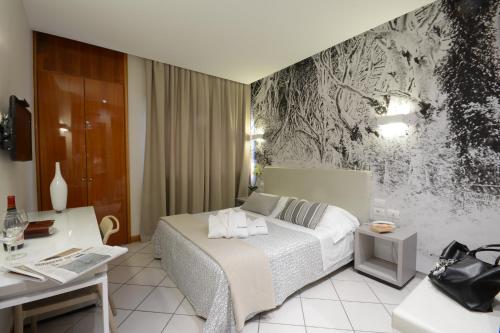 ルッカにあるHotel Napoleonのベッドとデスクが備わるホテルルームです。