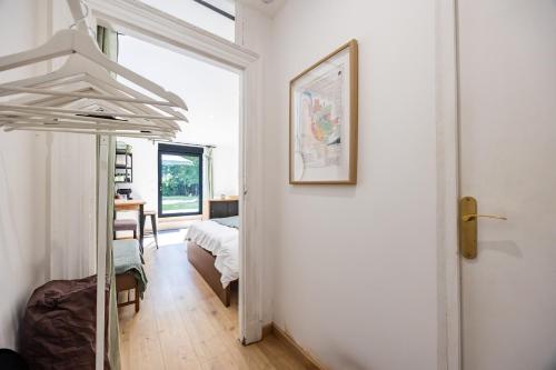 a white room with a bed and a mirror at Studio Bord-Eau, terrasse et jardin in Saint-André-de-Cubzac