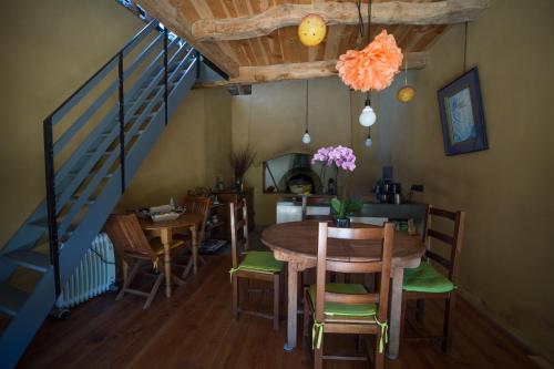 a dining room with a table and chairs and a staircase at Chambre d'hotes La Source Aveyron in Saint-André-de-Najac