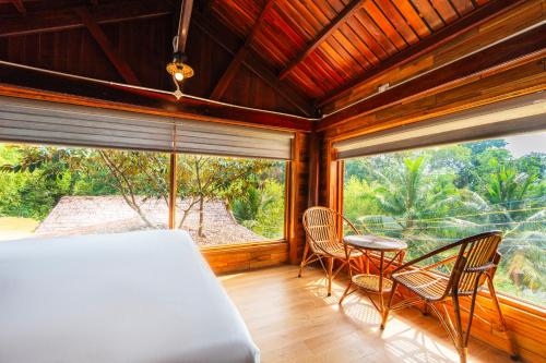 a bedroom with a bed and a table and chairs at Mango Village in Phú Quốc