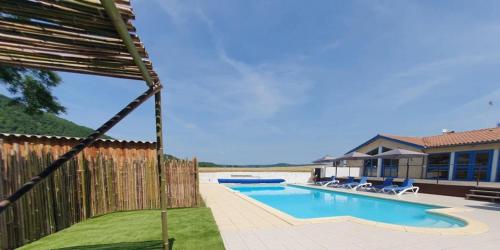 a swimming pool in front of a house at Camping 3 étoiles - Piscine - ccbgbeh in Puy-lʼÉvêque