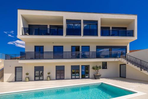a house with a swimming pool in front of it at Luxury apartment LaRiv II with pool in Krk