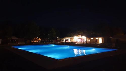 a swimming pool at night with a building in the background at Camping 3 étoiles - Piscine - ccbgbi0 in Lavelanet