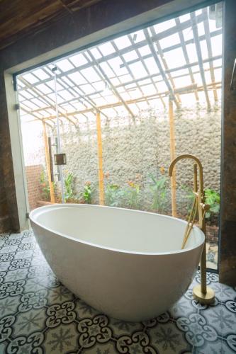 a large bath tub in a bathroom with a window at Laco Green Trang An in Yên Ha