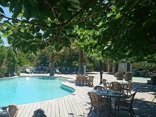 a swimming pool with chairs and a table and a table and chairs at Chalet 2 étoiles - Piscine - ccbgdfh in Porto-Vecchio
