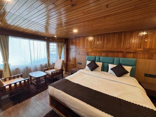 a bedroom with a large bed in a room at Hotel Queen in Darjeeling