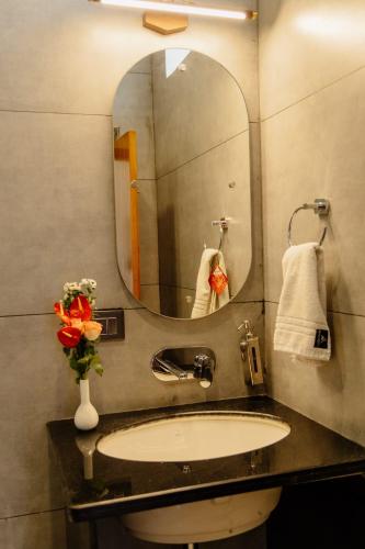 a bathroom with a sink and a mirror at The Twelve Petals by Parvati Inn in Dhikuli