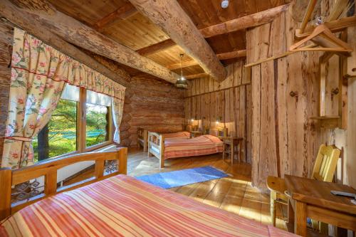 a bedroom in a log cabin with a bed and a couch at Greete Motel in Soontaga