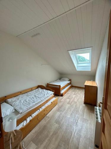 two beds in a room with a window at La marmotte namuroise in Saint-Jean-d'Aulps