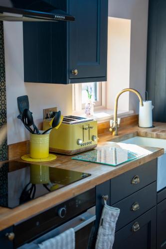 a kitchen with blue cabinets and a counter top at Orchard Barn in Teversall