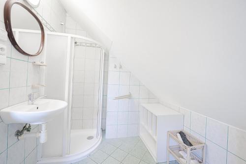 a white bathroom with a sink and a mirror at Apartman Nina in Kvačany