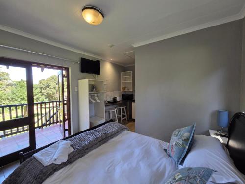 a bedroom with a bed and a balcony at Azalea at Greenway Woods in White River