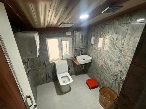 a small bathroom with a toilet and a sink at Zabaish Riverside Cottage in Pahalgām