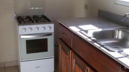 a kitchen with a stove and a sink at Raquel House in Dolega