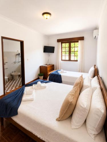 a large bedroom with two beds and a bathroom at Serrana Gerês Inn in Geres
