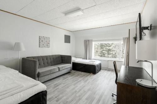 a hotel room with a couch and a bed at FolkiaCenter Gästhem - Vieraskoti - Guesthouse in Hanko