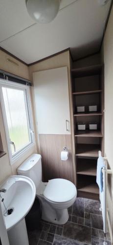 a small bathroom with a toilet and a sink at The Minver - Park Dean Resort in Saint Minver