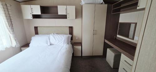 a small bedroom with a bed and a tv at The Minver - Park Dean Resort in Saint Minver