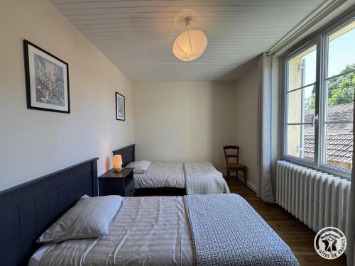 a bedroom with two beds and a window at Gîte brisset in Coulaures