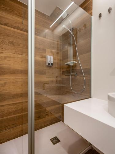 a bathroom with a shower with wooden walls at Limehome Barcelona Carrer de Fontcoberta - Digital Access in Barcelona