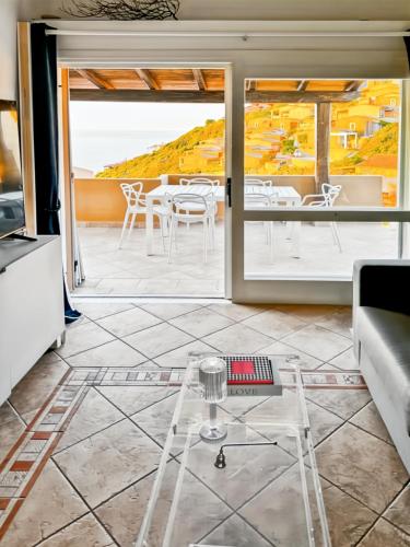 a living room with a table and a view of the ocean at Casa il Bouganville - sea view Costa Paradiso in Costa Paradiso
