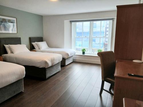 a hotel room with two beds and a window at Henehan's Town House in Westport