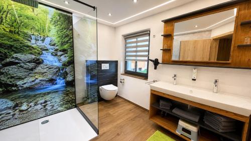 a bathroom with a waterfall mural on the wall at Familotel Der Böhmerwald in Eschlkam