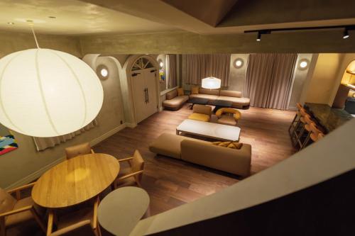 a living room with a couch and a table and chairs at SOSHIJI Arashiyama in Kyoto