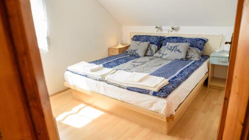 a bedroom with a bed with blue sheets and pillows at Magyar Tenger Pihenőház, for 2-8 person, 105 m2, garden, pool, free parking, 5 min from the Lake, Balatonakarattya in Balatonakarattya