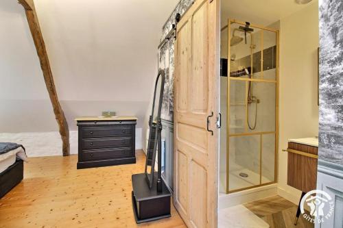 a bathroom with a refrigerator and a walk in shower at Le petit cottage in Ruffiac