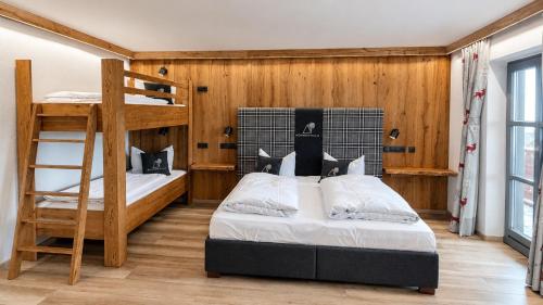 a bedroom with two bunk beds and a ladder at Familotel Der Böhmerwald in Eschlkam