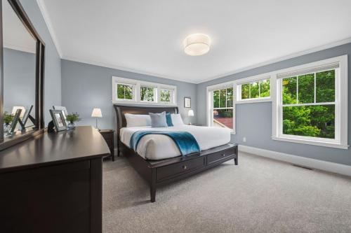 a bedroom with a bed and a desk and windows at Casa Roja in Edina