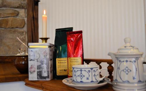 a table with a candle and some tea cups on it at Hotel & Café Mohrenbrunnen in Eisenberg