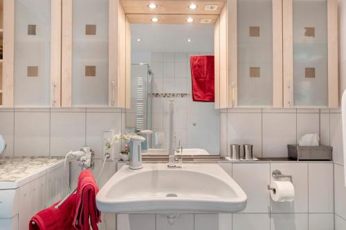 a white bathroom with a sink and a red towel at Ferienwohnung Paffendorf in Gutach