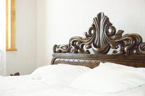 a close up of a bed with a wooden headboard at Guesthouse Zedafoni in Zestafoni