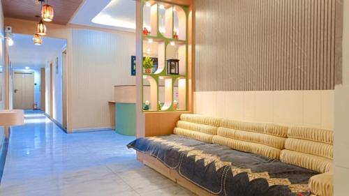 a lobby with a couch in the middle of a room at Hotel Harmony Inn in Ahmedabad