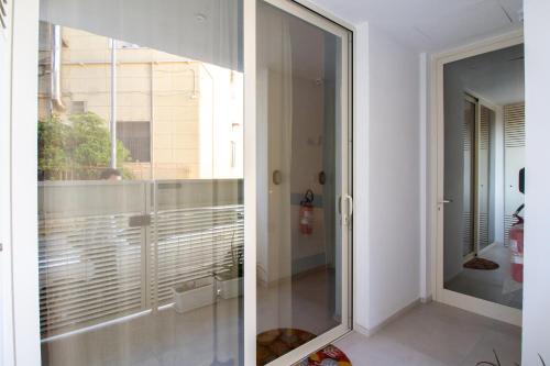 a glass door in a room with a balcony at Idumea Rooms in Lecce
