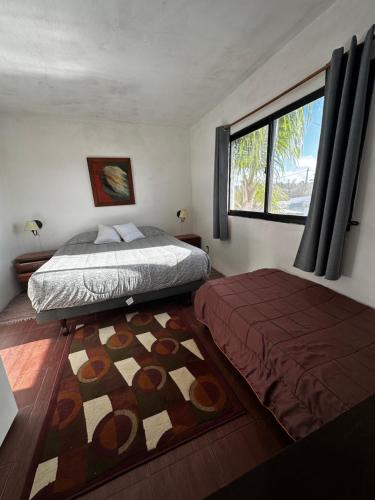 a bedroom with a bed and a window and a rug at Casa Estrella de Mar in La Paloma