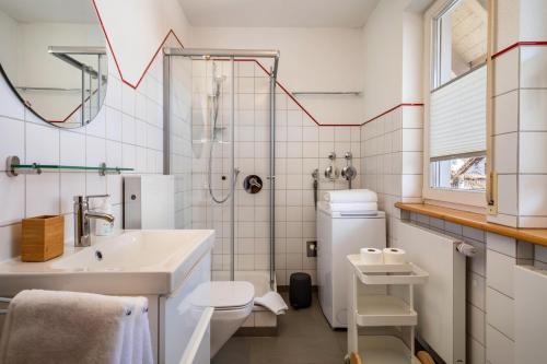 a white bathroom with a sink and a shower at Haus Grete in Langenargen