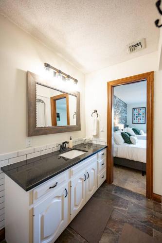 a bathroom with a sink and a mirror and a bed at Lakefront Group Stay, Sleeps 19, Indoor Pool, Hot Tub, Arcades in Terre Haute