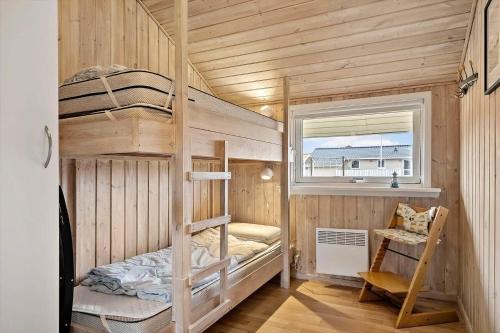 a bunk bed in a wooden room with a window at 358-Hvide-Sande-Fyrmarken-25 in Hvide Sande